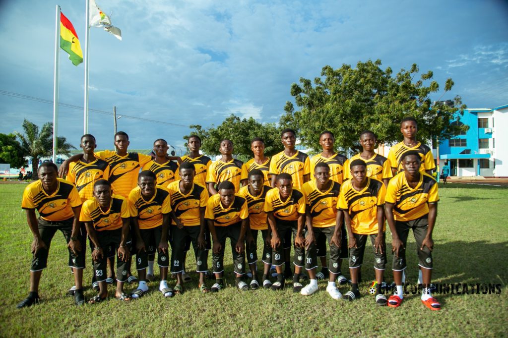 Jeunes joueurs de football ghanéens en action sur un terrain