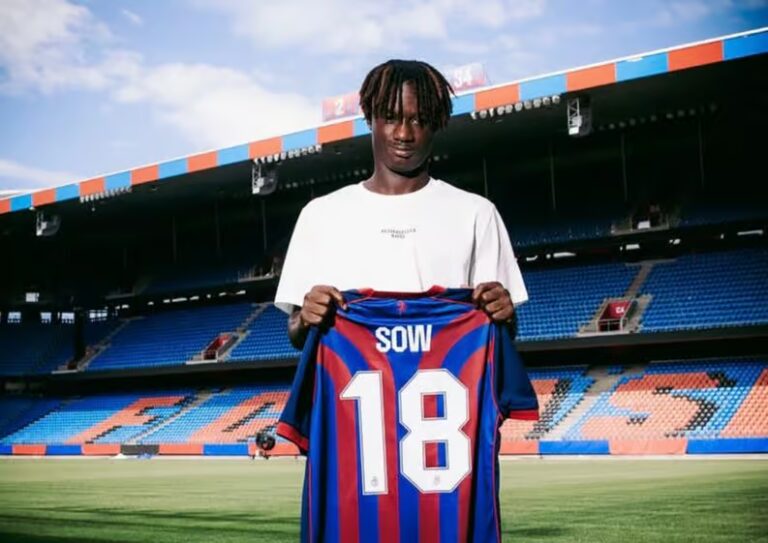 Assane Sow souriant avec le maillot du FC Bâle lors de la signature de son contrat