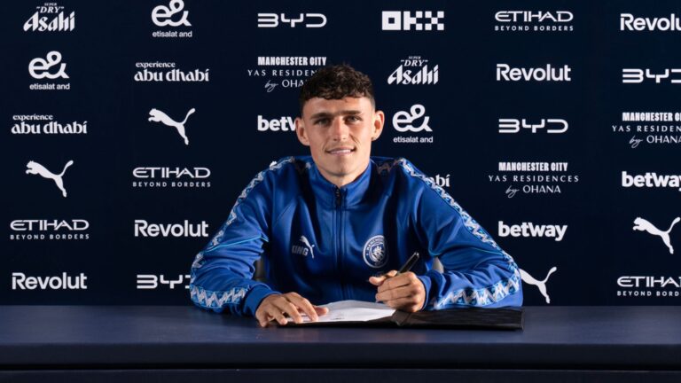 Phil Foden souriant lors de la signature de son contrat avec Manchester City