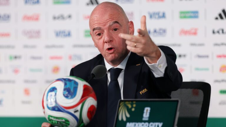 Gianni Infantino en conférence de presse devant le logo de la FIFA